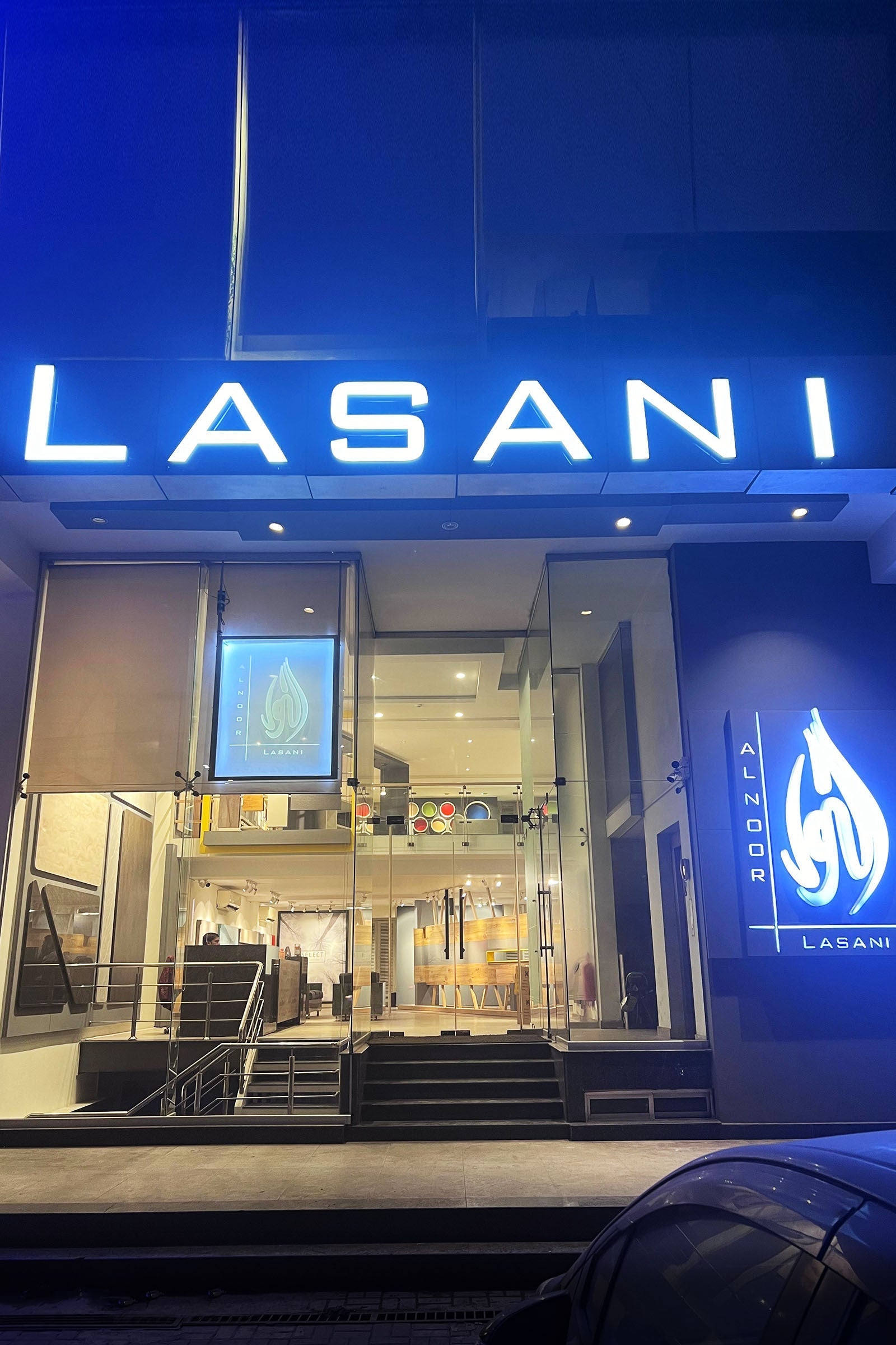 Modern business storefront with illuminated LASANI signage and glass entrance at night