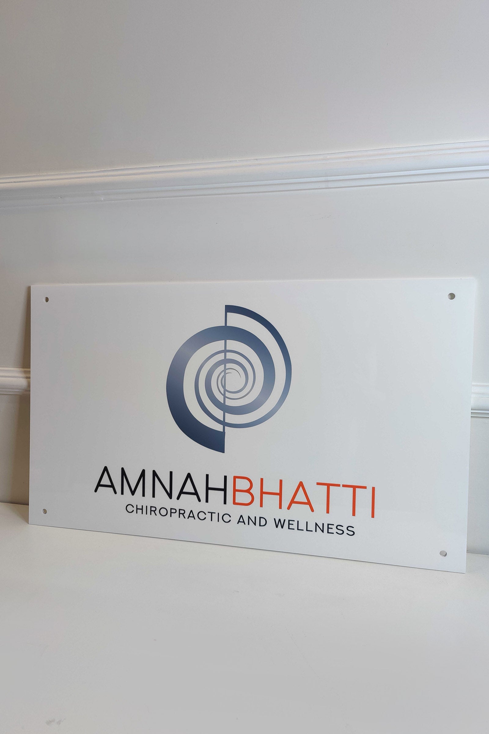 Custom acrylic business signage for chiropractic and wellness office on white background.